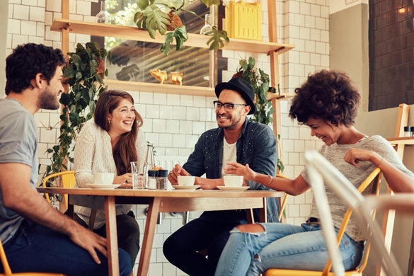 Group of friends enjoying in cafe together - How Does an Aries Man Act When He’s in Love