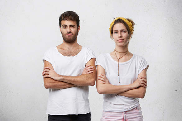 Angry stubborn man and woman standing in closed postures - What are some of the Aries Man Worst Habits